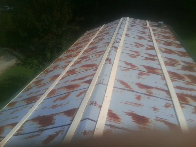 Rusted metal roof panels with new wood purlins before replacement — Storm Damage Roof Repair in Smithville by Roofing Brothers
